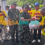 Danrem 081/DSJ, Kolonel Inf Sugiono, saat memberi bantuan kepada warga. Foto: HENDRO SUHARTONO/BANGSAONLINE
