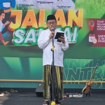 H. Husnul Khuluq memberikan sambutan saat melepas Jalan Santai Hari Santri Nasional 2023 di depan Gedung Negara Grahadi, Surabaya. Foto: Ist.