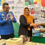 Kepala Dnas Kominfo Jatim Sherlita Ratna Dewi Agustin memberikan potongan kue tart kepada CEO HARIAN BANGSA M. Mas