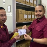 Kepala Kantor Imigrasi Malang Galih Priya Kartika Perdhana (kanan) menunjukkan barcode yang akan ditempel pada box file.