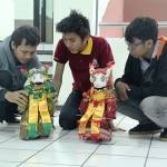 ?Tiga mahasiswa sedang mengoperasionalkan robot joget.Foto:nisa/BANGSAONLINE