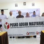Bawaslu Kota Pasuruan saat menunjukkan banner Posko Aduan Masyarakat.