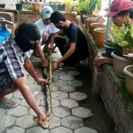 Warga sedang mengukur panjang ular sanca kembang yang ditemukan di rumah warga. foto: ist.