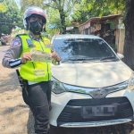 Petugas menunjukkan STNK mobil Toyota Calya yang diduga palsu.
