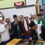 Ketua PCNU Kota Surabaya KH. Dr. Ahmad Muhibbin Zuhri menandatangani prasasti maklumat Masjid Abu Adenan sebagai masjid yang berpedoman pada amaliah, ubudiyah, dan iktiqadiyah Aswaja An Nahdliyah. foto: DIDI ROSADI/ BANGSAONLINE