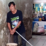 Cara Pujianto memeras peralatan pel yang digunakan untuk membersihkan lantai PBM masih manual menggunakan tangan. Foto: HENDRO SUHARTONO/ BANGSAONLINE
