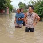 Camat Balongpanggang M. Amri Maulana saat turun melihat warganya yang kebanjiran dampak luapan Kali Lamong. foto: SYUHUD/ BANGSAONLINE