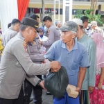 Petugas dari Polres Lamongan saat membagikan sembako untuk masyarakat.