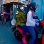 Wali Kota Surabaya Tri Rismaharini bonceng sepeda motor keliling Surabaya Utara untuk memberikan masker sekaligus mengingatkan warga tentang protokol kesehatan, Ahad (6/9/2020). foto: ist.