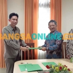 Ketua PN Bangil, Arizal Anwar, saat menunjukkan MoU yang telah ditandatangani bersama LBH Peradi Malang Raya. Foto: AHMAD FUAD/BANGSAONLINE