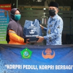 PEDULI & BERBAGI: Ketua Korpri Kabupaten Sidoarjo Achmad Zaini menyerahkan bantuan sembako bagi korban terdampak Corona, Jumat (17/4). foto: ist.