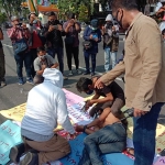 TEATRIKAL: Aksi wartawan Sidoarjo sikapi kasus kekerasan terhadap wartawan Tempo, di Alun-alun Sidoarjo, Senin (29/3/2021). foto: MUSTAIN/ BANGSAONLINE