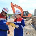 Dua pekerja sedang mengecek progres pembangunan fasilitas di Lapangan J-TB.