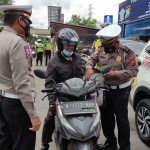 Petugas memeriksa isi tas pengendara motor di perbatasan Sidoarjo-Surabaya.