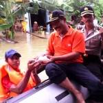 BANTU. Camat Kebomas, Jaerudin ketika memberikan bantuan nasi bungkus kepada korban banjir. foto : syuhud/bangsaonline