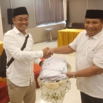 Ketua BPS Nanang Qosim menyerahkan kain berisi tanda tangan dukungan ke Wakil Ketua DPD Partai Gerindra Jawa Timur, Satib.
