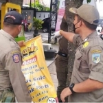 Petugas Satpol PP Kabupaten Kediri saat mencopoti reklame yang dipaku di pohon, berkat laporan warga melaui aplikasi Halo Mas Bup. (foto: Kominfo).