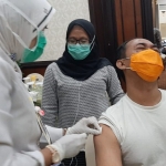Nyoman Denny wartawan dari Kompas TV diberikan vaksin influenza. Sementara Fatimatuz Zahroh wartawati Harian Surya menunggu giliran divaksin. foto: ist.