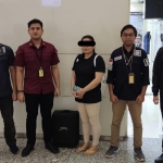 Seksi Inteldakim Kantor Imigrasi Malang mengawal WNA China LXM (tengah) yang dideportasi ke negara asalnya.