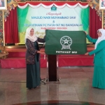 Serah terima bendera dan kunci kantor Fatayat NU dari ketua periode sebelumnya Ny. Hj. Nafidatul Qudsiyah (kanan) kepada ketua masa khidmat 2019-2024 Ny. Hj. Nur Anisyah.