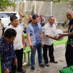 Kepala DKPP Kota Kediri M. Ridwan (kanan) saat menyerahkan bantuan benih ikan kepada pengelola sumber air. Foto: Ist.