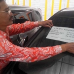 Seorang pegawai Pemkot Mojokerto memampang harga lelang dan copian berkas mobdin yang akan dilempar ke pasar publik.