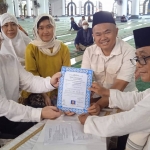Timothy John Rogerson (kiri) memegang surat pernyataan masuk Islam yang baru ditandatangani bersama Dr KH M Sujak, M.Ag (kanan) di Masjid Al-Akbar Surabaya, Selasa (12/3/2024). Foto: masjidalakbar.or.id 