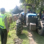Truk pengangkut beras yang nyelonong ke jalan makam desa sedang dievakuasi menggunakan traktor. foto: ist.