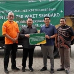 Bupati Gresik, Fandi Akhmad Yani, didampingi Kepala BPBD Darmawan menerima bantuan paket sembako dari Petrokimia Gresik untuk korban banjir. FOTO: SYUHUD/BANGSAONLINE.com
