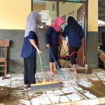 Para guru SDN 1 Talun Kulon saat membersihkan lumpur yang terbawa saat banjir bandang menerjang.