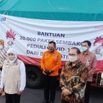 Gubernur Jatim Khofifah Indar Parawansa yang juga Ketua Gugus Tugas Percepatan Penanganan Covid-19 Jawa Timur menerima paket bantuan sembako dan uang tunai dari Bank Jatim. foto: ist.