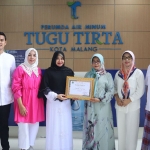 Jajaran Manajemen Perumda Tugu Tirta menunjukkan piagam penghargaan dari Pemkot Malang.