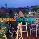 Pengunjung Maungopi Cafe saat menikmati pemandangan Kota Jombang dari ketinggian. Foto: AAN AMRULLOH/BANGSAONLINE