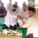 Wali Kota Madiun Maidi menyerahkan pucuk tumpeng kepada ahli waris makam.