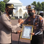 Kapolres Pasuruan, AKBP Bayu Pratama Gubunagi, saat memberi penghargaan untuk personel berprestasi.