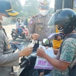 Kapolres Kediri Kota AKBP Miko Indrayana didampingi oleh Kasatlantas Iptu Arpan, saat membagikan masker kepada pengguna jalan. foto: ist.