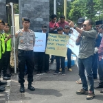 Koordinator Aksi Lujeng Sudarto saat berorasi menuntut penyidik mengungkap aktor utama korupsi dana hibah Provinsi Jatim.