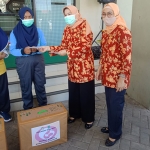 Suhanik, Ketua Dharma Wanita Kabupaten Pasuruan didampingi Ketua Unsur Pelaksana Dishub Kabupaten Pasuruan Nik Sugiharti saat menyalurkan sembako. (foto: ist)
