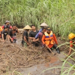 Tim gabungan dibantu warga saat susur sungai melakukan pencarian terhadap korban. foto: RAFLI FAJRI JULIANTO/ BANGSAONLINE