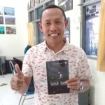 Ketua Komunitas Wartawan Gresik (KWG) M. Syuhud Almanfaluty menunjukkan buku Telisik Hati karya Didik Hendriyono.