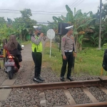  Anggota Satlantas polres Ngawi melakukan upaya pencegahan kecelakaan di perlintasan kereta api.