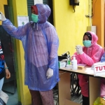 Petugas medis salah satu Puskesmas menggunakan jas hujan plastik lantaran stok APD yang dimiliki Dinkes Kota Malang terbatas. foto: ist.