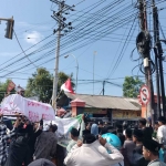 Ratusan massa saat menggelar aksi di depan kantor Bawaslu dan KPU Bangkalan sambil membawa keranda mayat sebagai simbol matinya demokrasi, Senin (19/2/2024).