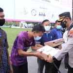Kapolres Madiun, AKBP Anton Prasetyo, saat memberikan bantuan sembako secara simbolis dari KLT Official.