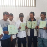 Delapan petani garam menunjukkan sertifikat tanah yang dimilikinya.