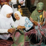 Gubernur Jawa Timur Khofifah Indar Parawansa menyelami cara menganyam kerajinan tas berbahan plastik. foto: bangsaonline.com