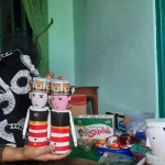 Endang Supriyani sedang menunjukkan suvenir berupa sepasang boneka dari limbah botol plastik bekas minuman. foto: MUJI HARJITA/ BANGSAONLINE