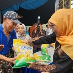 Khofifah saat membagikan beras gratis kepada masyarakat yang berusia lebih dari 65 tahun.
