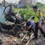 Petugas saat mengevakuasi Avanza yang terlibat kecelakaan dengan kereta di kawasan Desa Tawangsari, Kecamatan Taman, Sidoarjo.