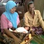 bayi tanpa anus, dalam gendongan ibu dan didampingi sang ayah. foto:ida okvinita/BANGSAONLINE